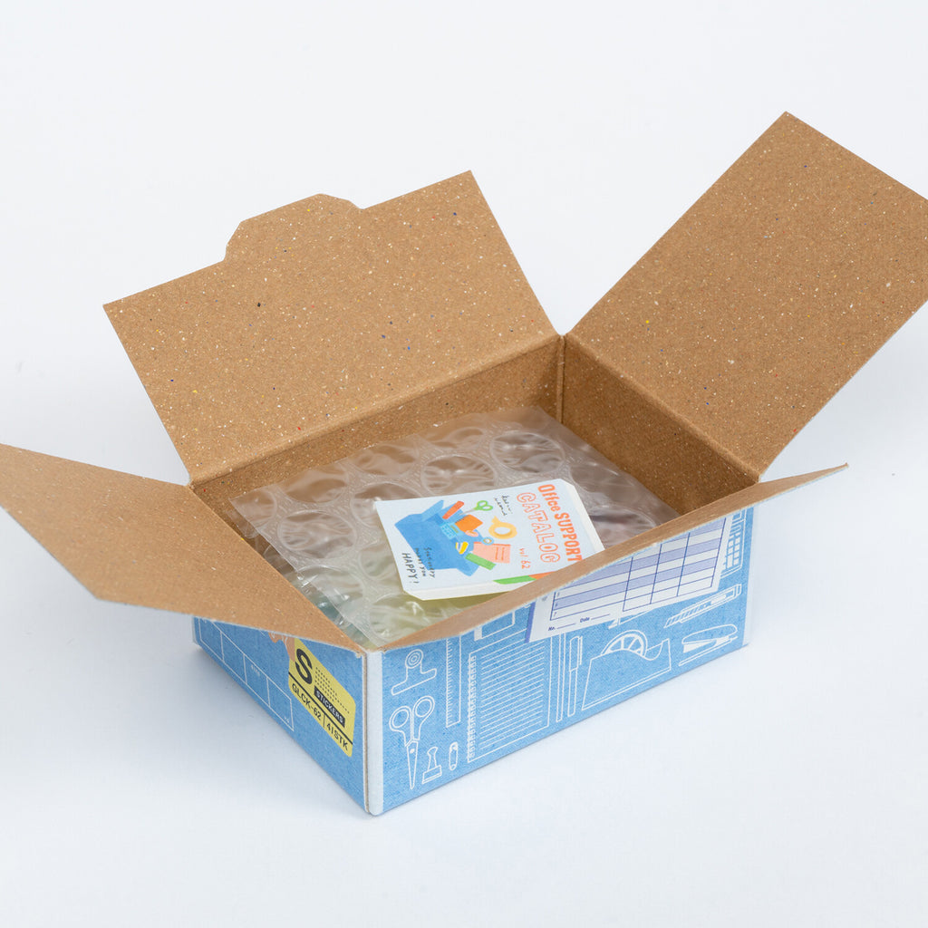 An open cardboard box revealing bubble wrap and a colourful sticker peeking through.