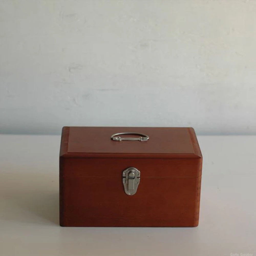 Brown wooden box with a silver handle and lock on a light gray background