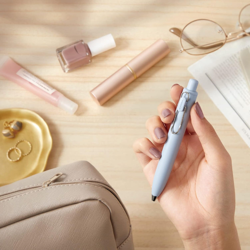 Uni-Ball One P pen displayed against a modern desk setting.