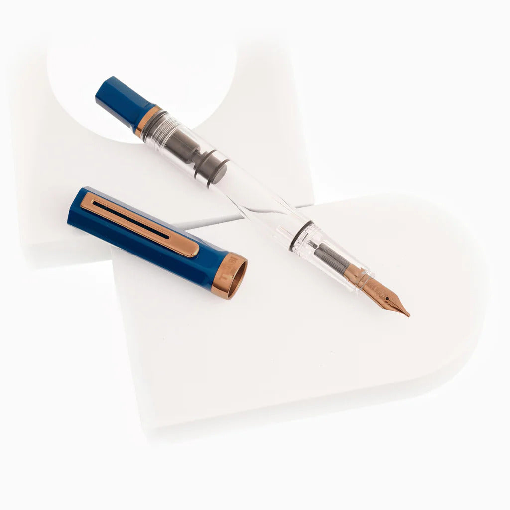 TWSBI Eco Fountain Pen in Indigo Blue with a clear barrel, bronze trim, and steel nib, designed for an elegant writing experience