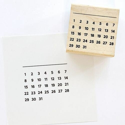 Wooden stamp featuring a numbered monthly calendar grid, ideal for bullet journaling or planners. Displayed on white paper. Measurements: 45 x 45 x 24mm.