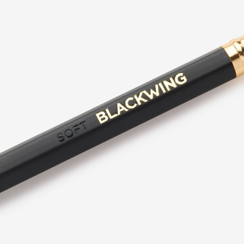 Detail view of the Blackwing Matte pencil showing the black barrel and gold-foil logo.