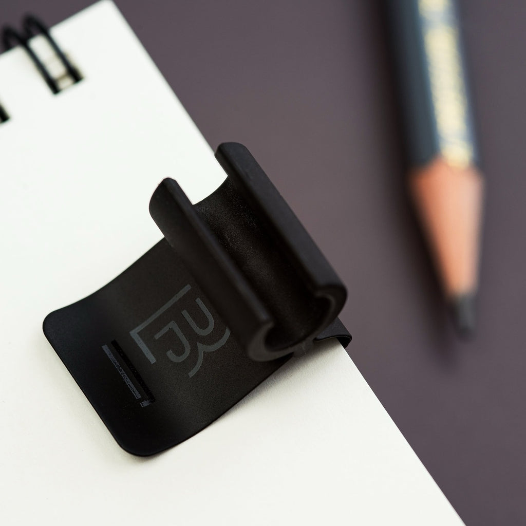 Side view of Blackwing Clip gripping notebook cover.