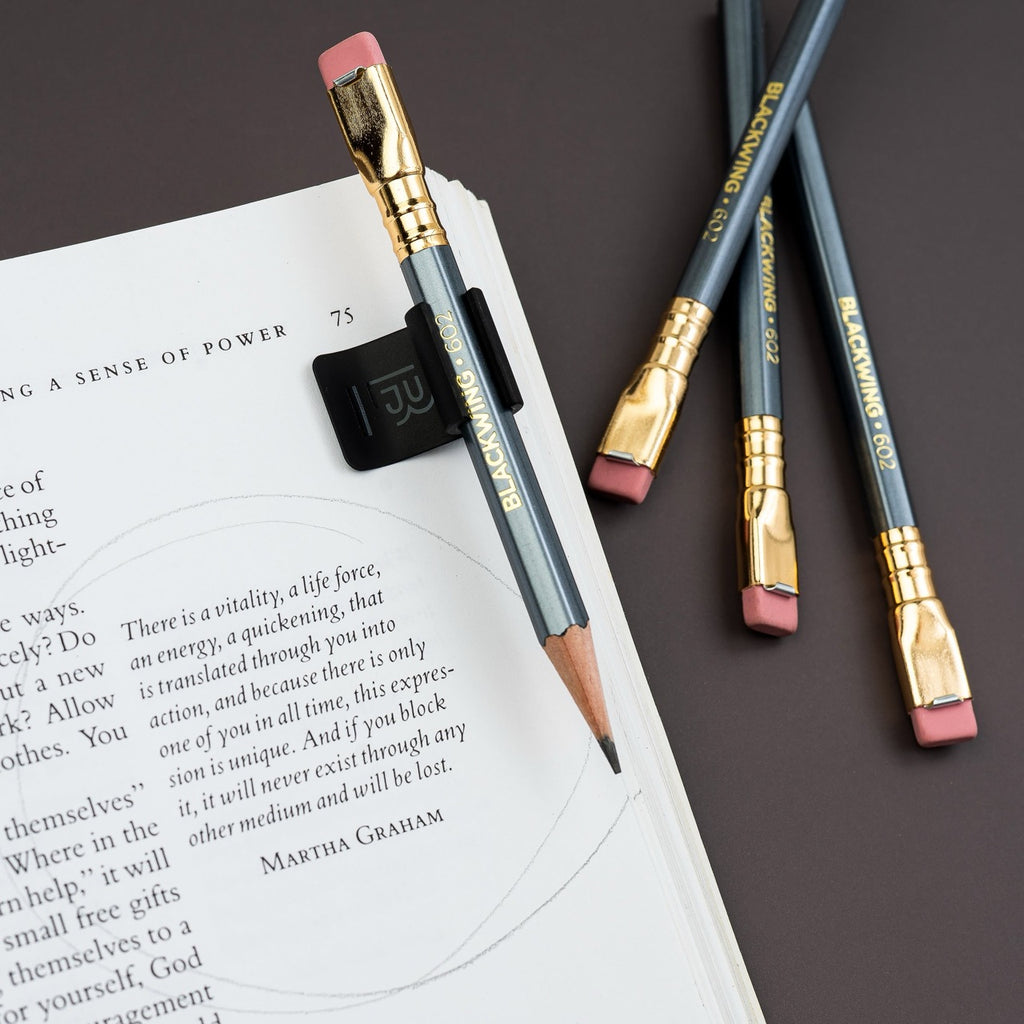 Blackwing Notebook Clip on desk with open book and spare pencils.