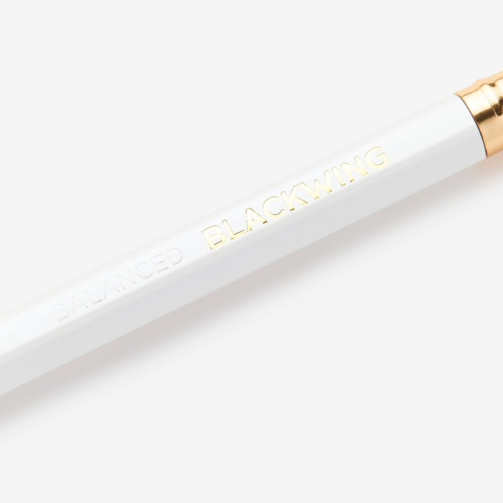 Detail view of the Blackwing Pearl pencil showing the white barrel and gold-foil logo.