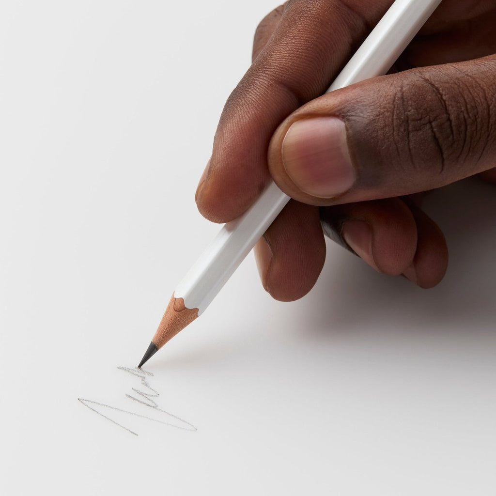 Person sketching with a Blackwing Pearl pencil on white paper.