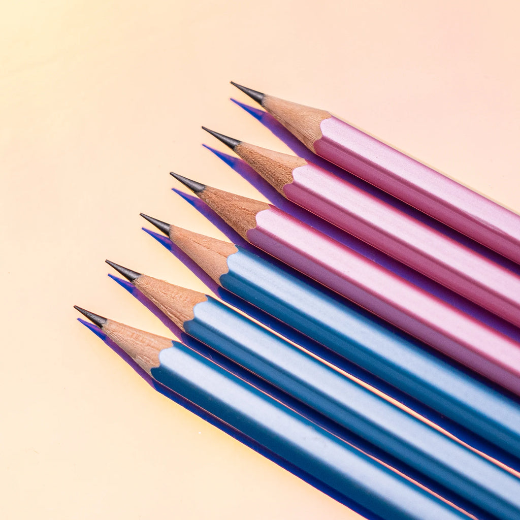 Assorted Blackwing Pearlescent pencils in blue and complementary colours laid out on a warm background.