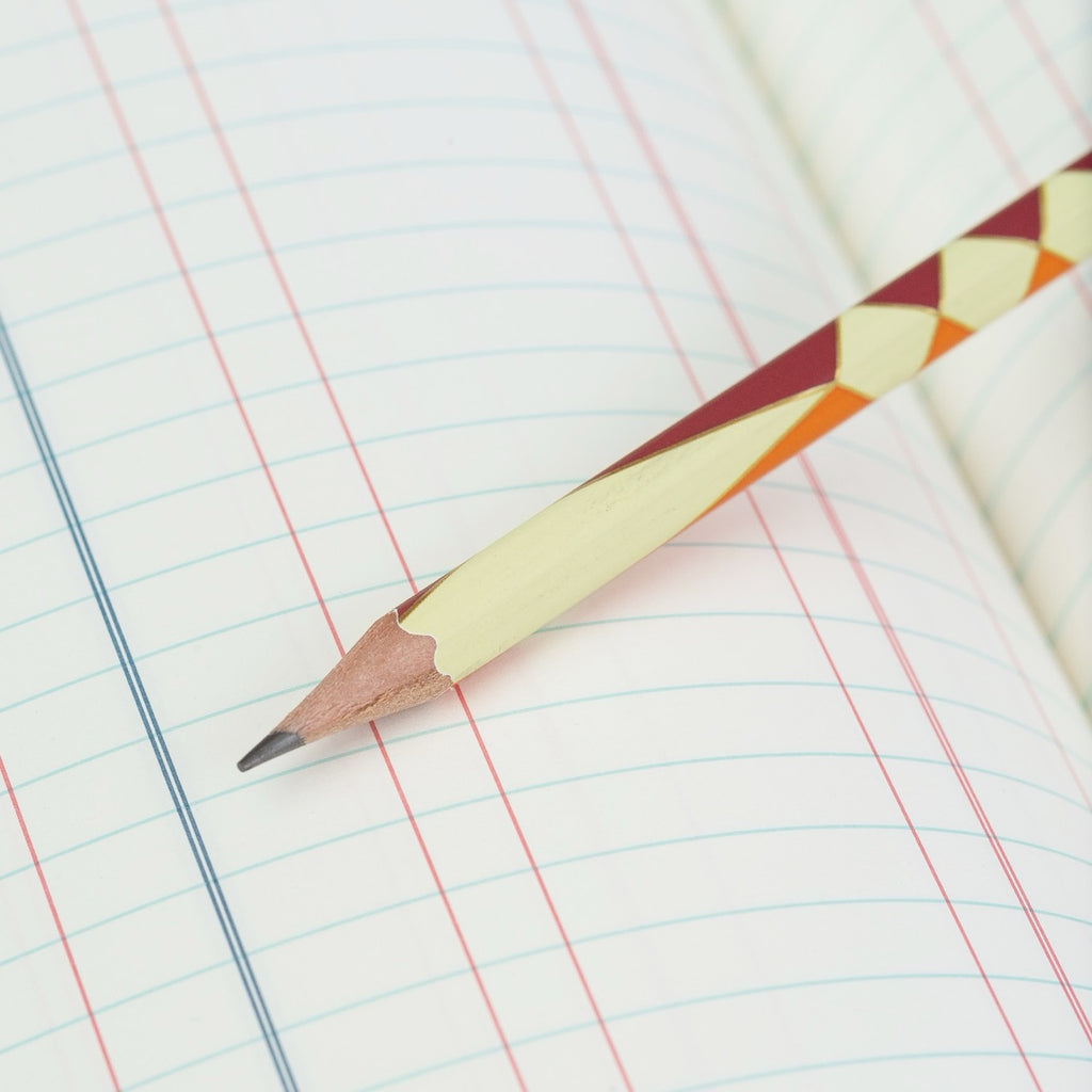 Blackwing Volume 574 pencil on a ledger book, highlighting firm graphite tip.
