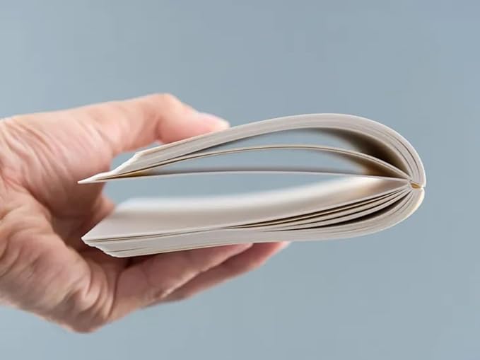 Hand holding CIRO notebook from the side, showing its slim flexible binding.