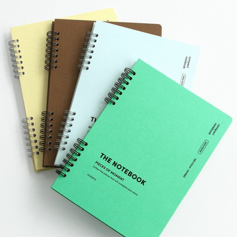 A selection of Iconic Compact A5 Grid Notebooks fanned out, displaying their colour range.