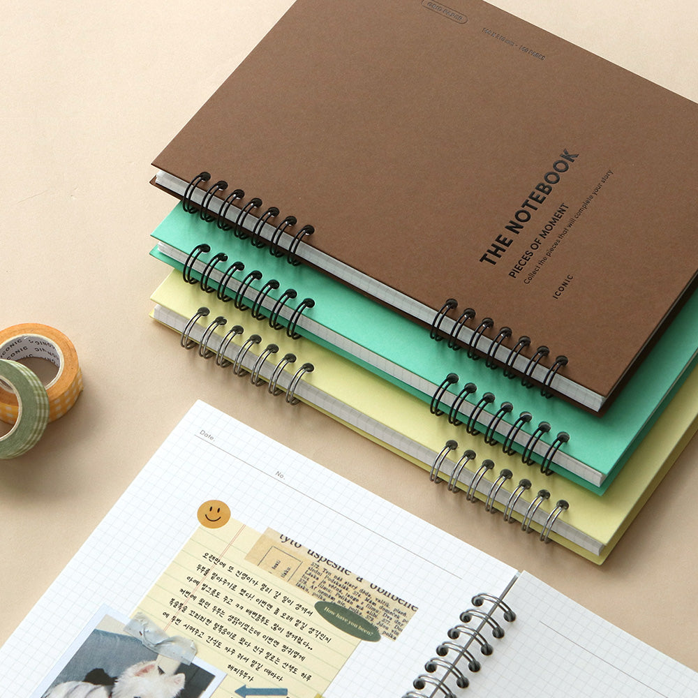 A stack of Iconic Compact A5 Grid Notebooks in various pastel colours