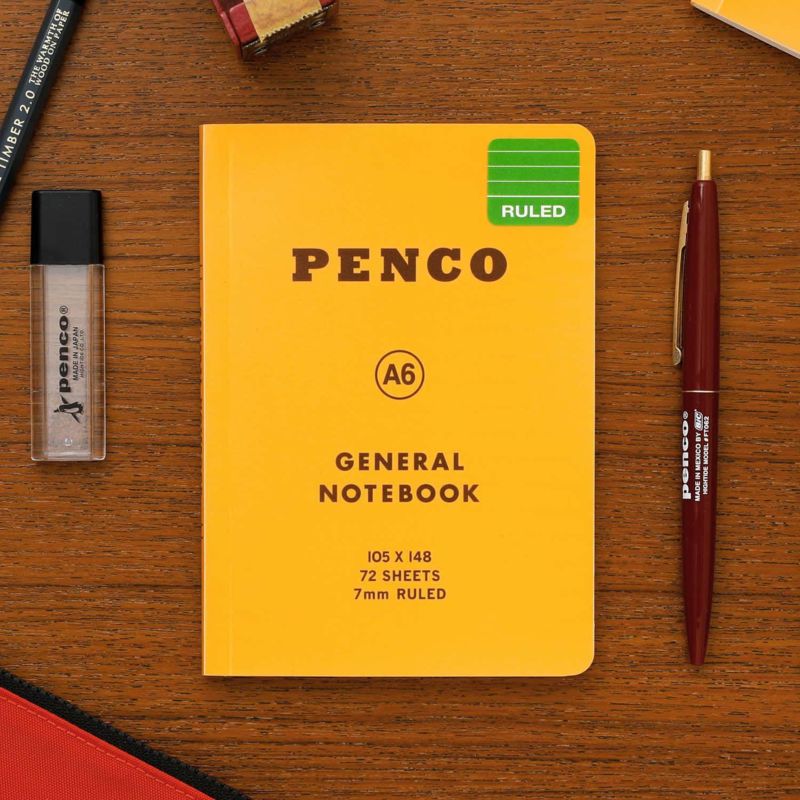 Hightide Penco Soft PP A6 ruled yellow notebooks lay flat on a desk alongside stationeries.