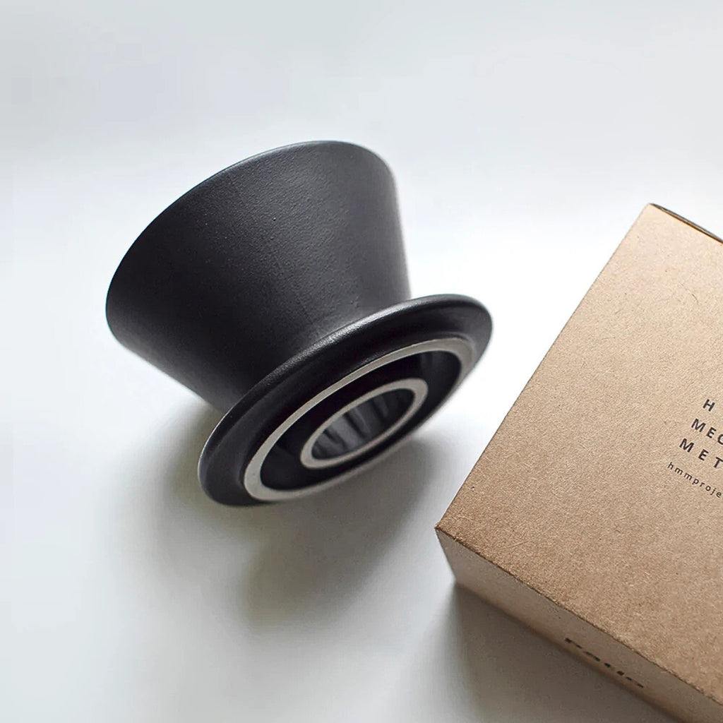 HMM Patio Coffee Dripper in matte black placed beside its branded packaging.