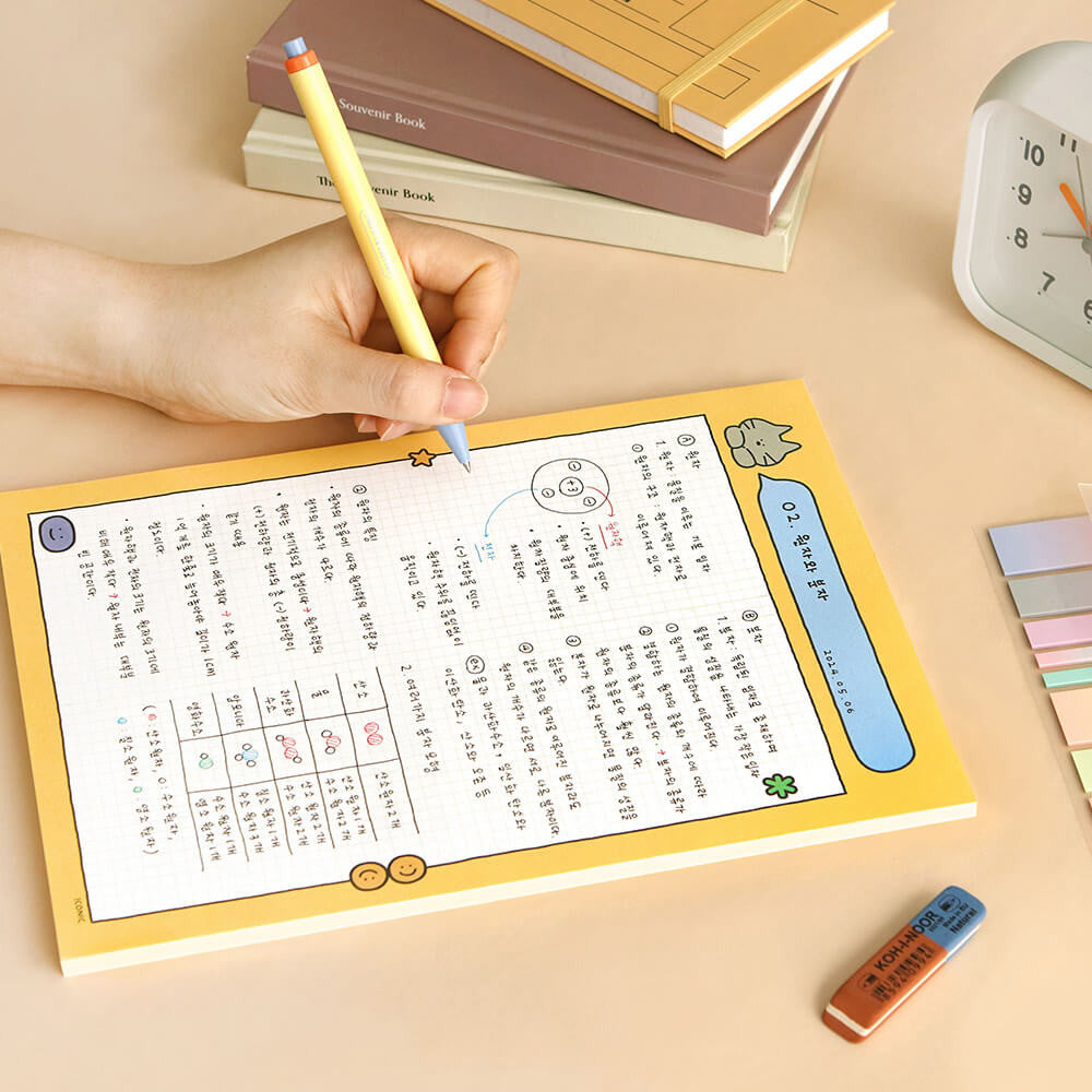 The Journal Shop - Iconic Doodle B5 Grid Notepad yellow cover version open with handwritten notes.