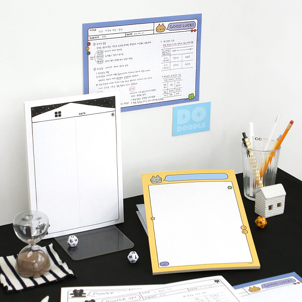 The Journal Shop - Iconic Doodle B5 Grid Notepad yellow and white versions displayed together on desk.