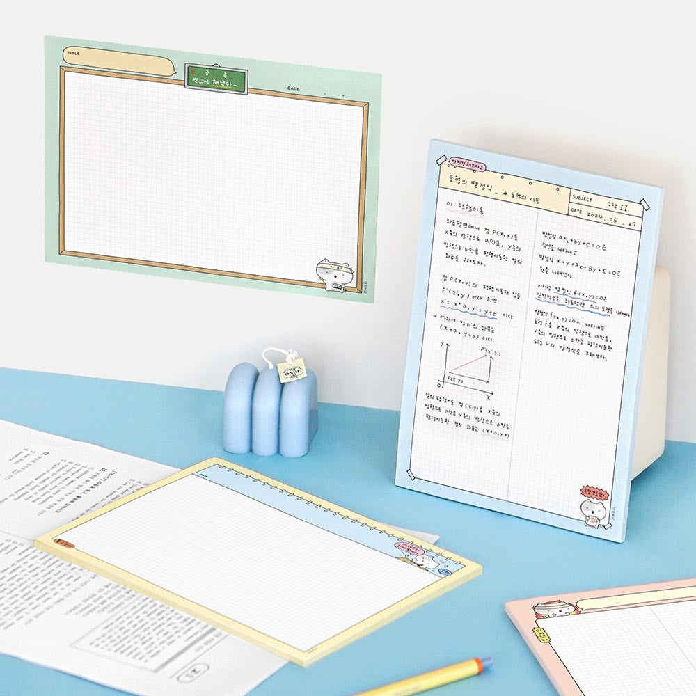 The Journal Shop - Iconic Blah Blah B5 Memo Notepad blue cover version open on desk with pencil and paper clips.