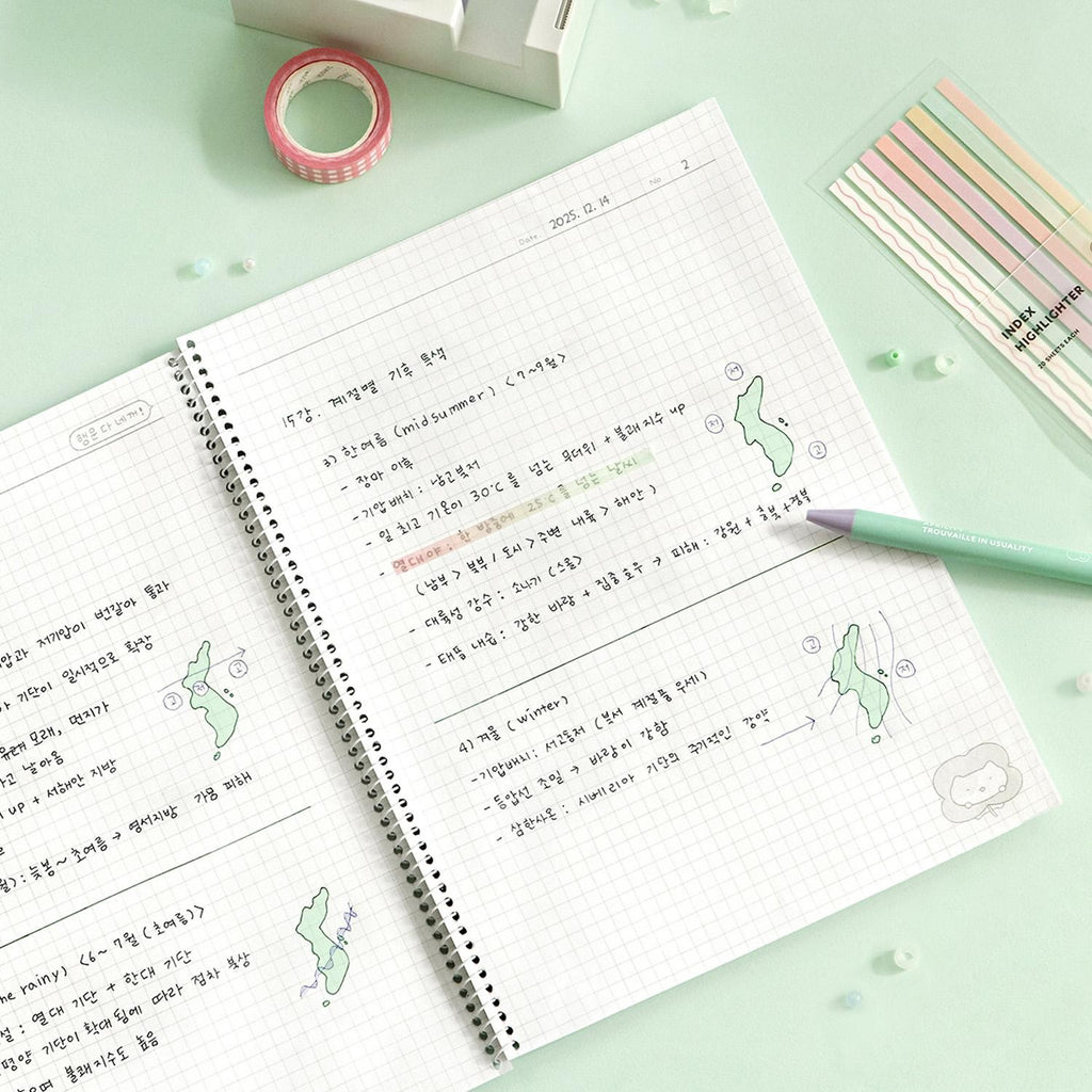 The Journal Shop - Iconic Blah Blah B5 Spiral Grid Notebook open with handwritten notes and pen on desk.