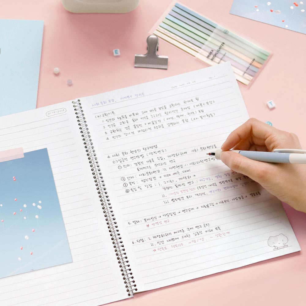 The Journal Shop - Iconic Blah Blah B5 Spiral Lined Notebook pastel pink cover being used for note-taking with pencil.
