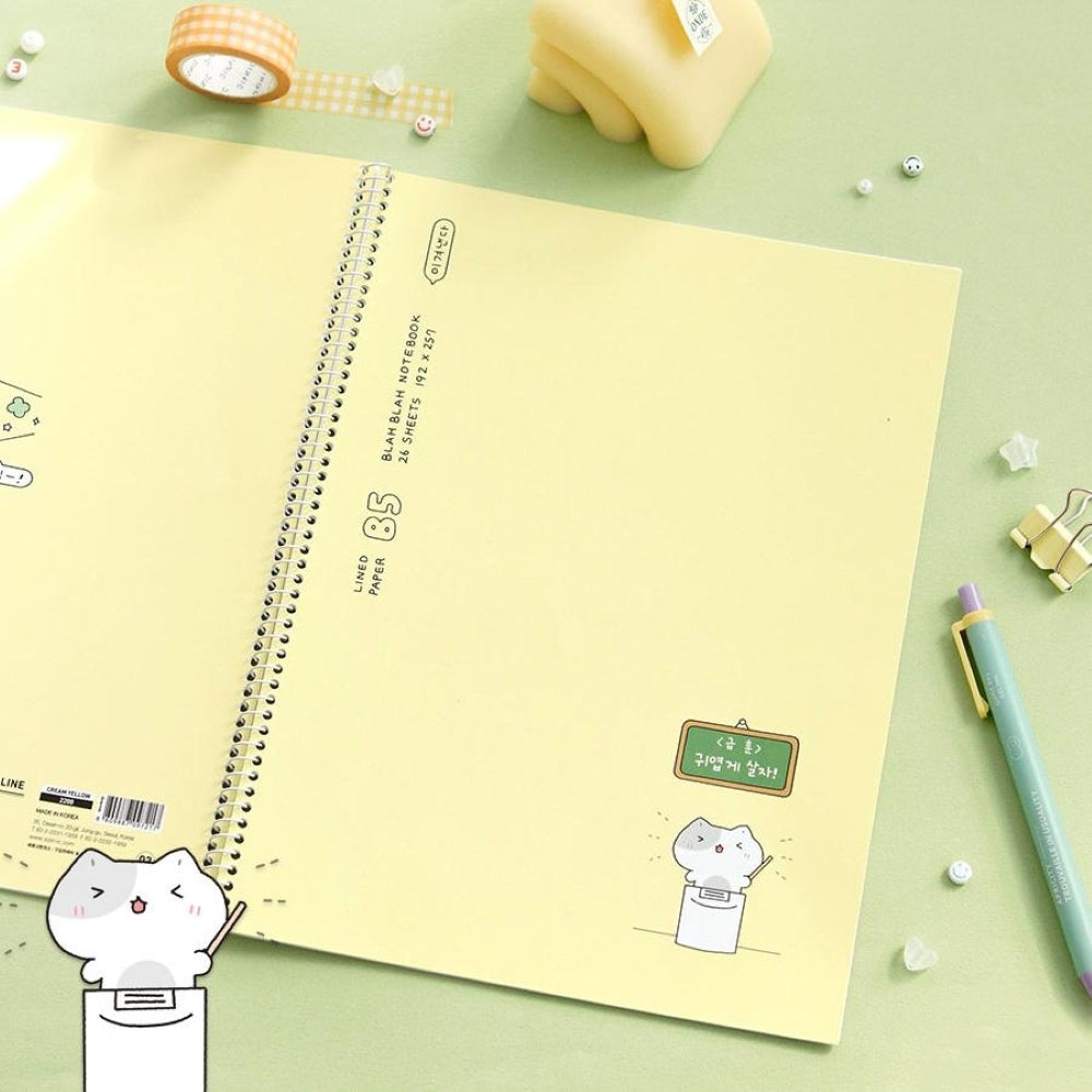 The Journal Shop - Iconic Blah Blah B5 Spiral Lined Notebook cream yellow cover shown with green pen and ruler.