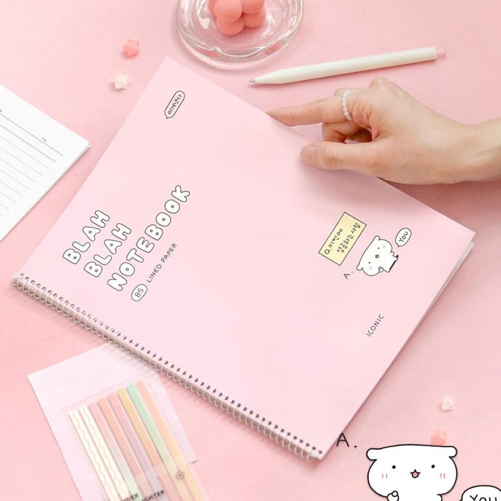 The Journal Shop - Iconic Blah Blah B5 Spiral Lined Notebook pastel pink cover displayed next to open pages and pink clip.
