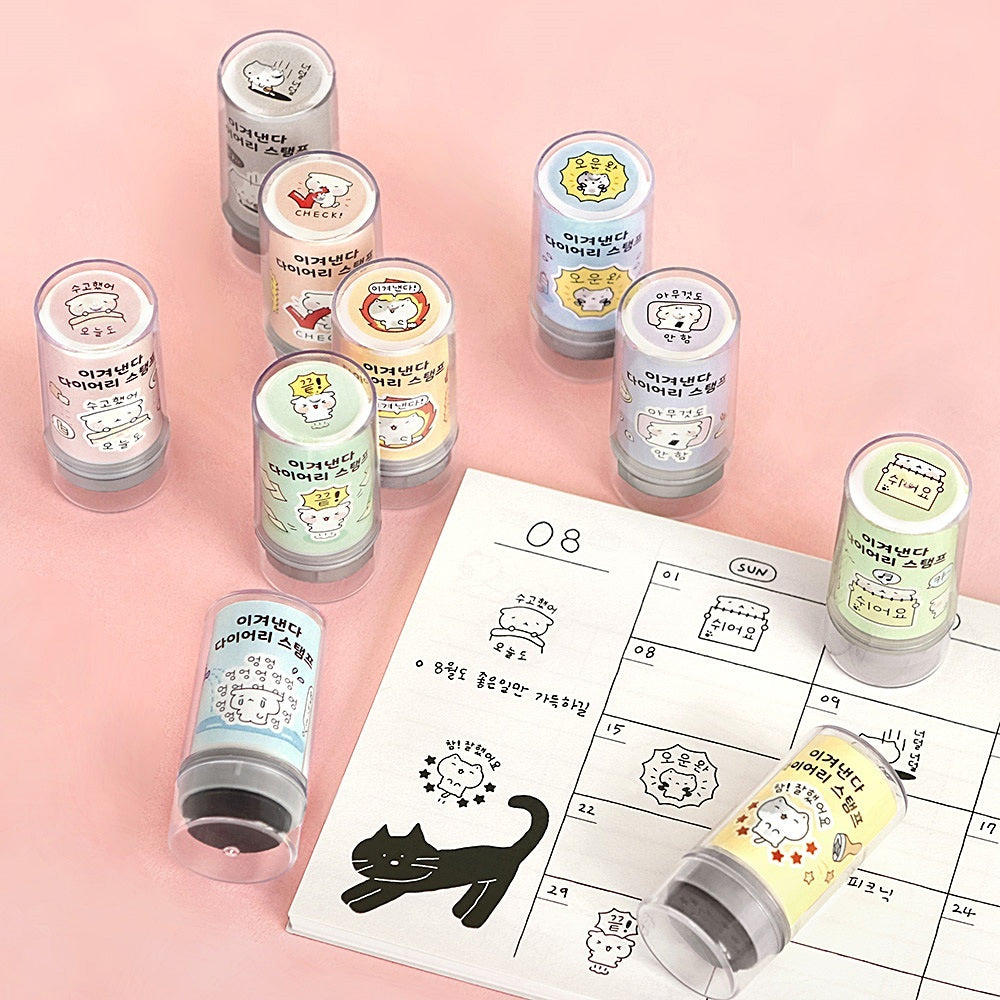 The Journal Shop - A selection of Iconic Blah Blah Diary Stamps in various pastel colours displayed on a pink surface beside stamped calendar pages.