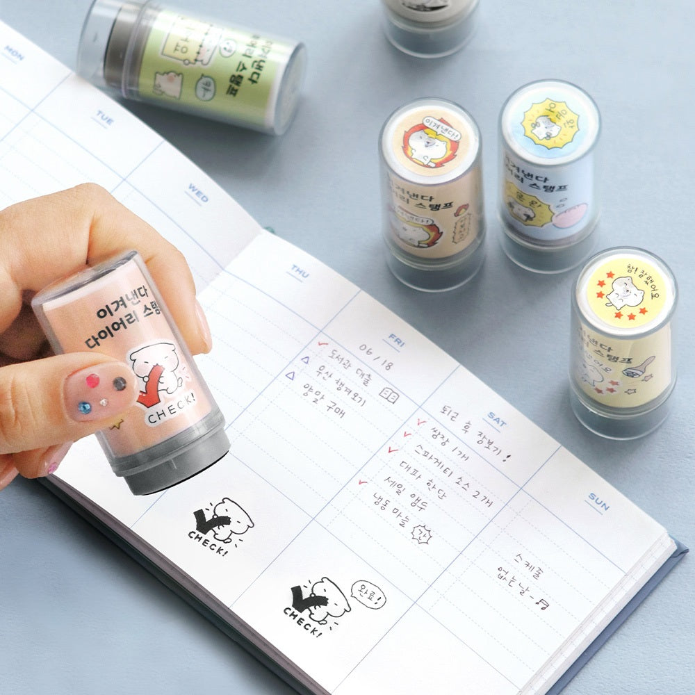 The Journal Shop - Hand using an Iconic Blah Blah Diary Stamp to decorate a planner page with small illustrated icons and text.