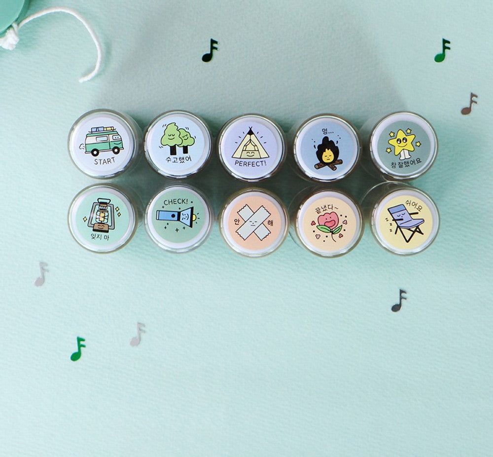 The Journal Shop - Top-down view of camping-themed stamp tops showing various illustrated icons such as tents and trees.