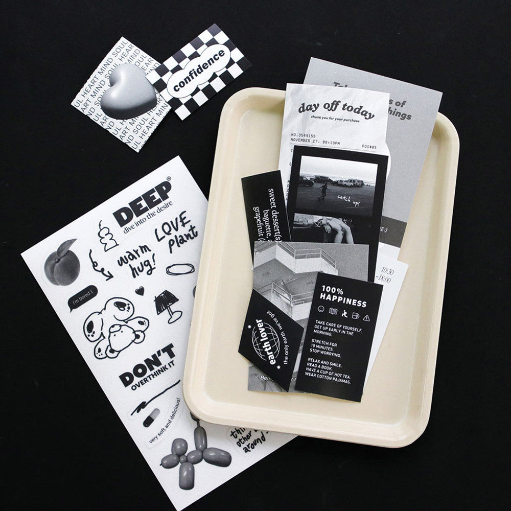The Journal Shop - Stationery flat lay showing notebooks, sticker sheets, and a clipboard with black-and-white designs.