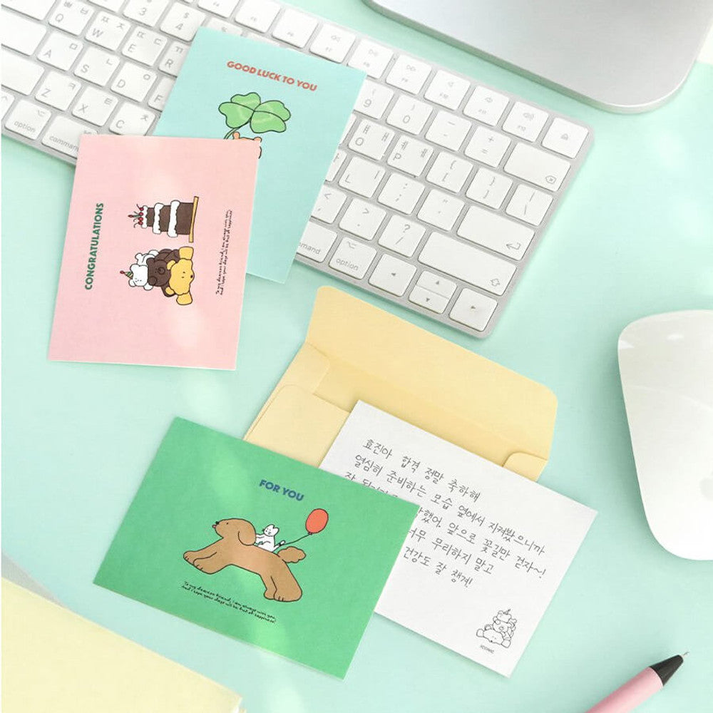 The Journal Shop - Iconic Cuddly Message Cards and envelopes arranged beside computer keyboard and stationery accessories.