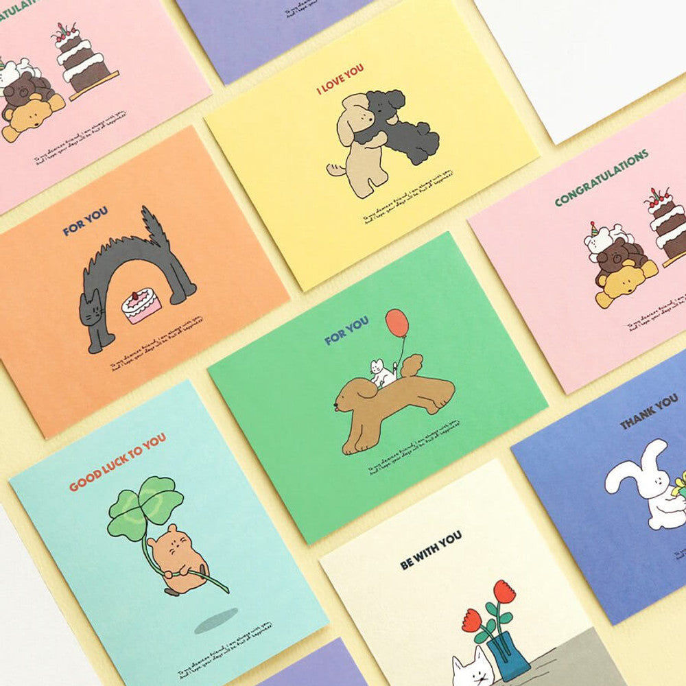 The Journal Shop - Iconic Cuddly Message Cards and envelopes spread out on pastel surface showing all designs.