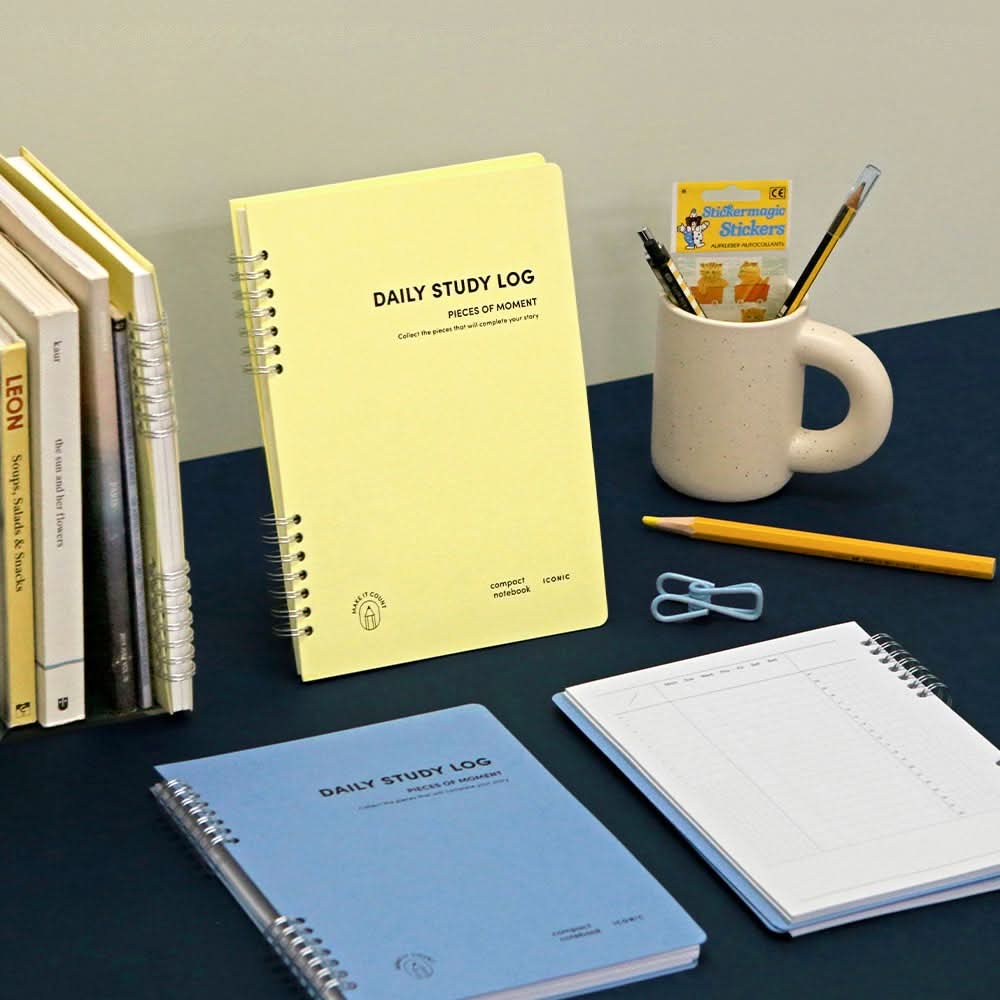 The Journal Shop - Iconic Daily A5 Study Planner dateless productivity notebook in yellow and blue covers displayed with stationery.