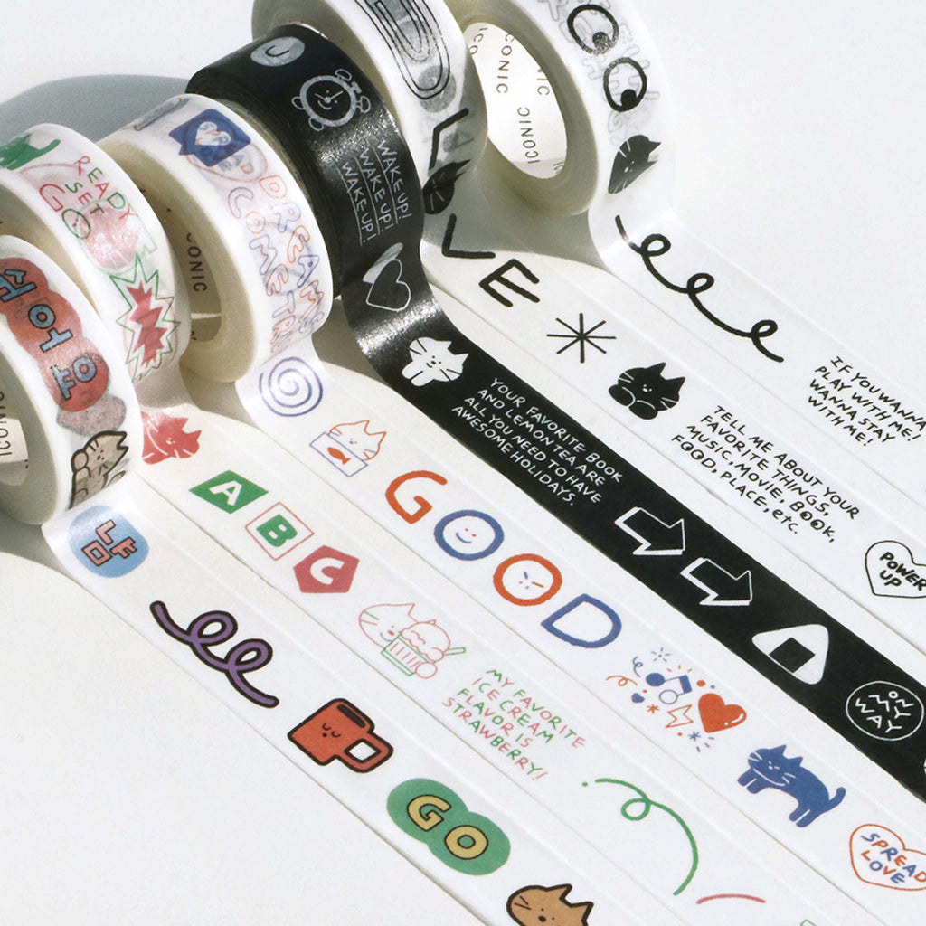 The Journal Shop - Close-up of multiple rolls of Iconic Doodle Masking Tape unrolled to reveal playful hand-drawn icons and text.