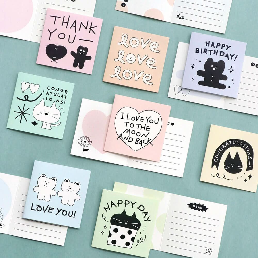 The Journal Shop - Iconic Doodle Mini Cards in multiple colours with doodle messages arranged flat on green surface.
