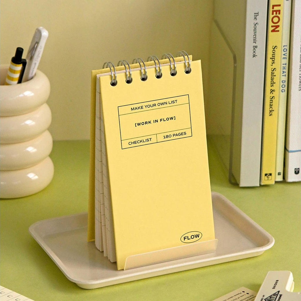 The Journal Shop - A yellow Iconic Flow Checklist placed on a beige tray with pen holder in the back.