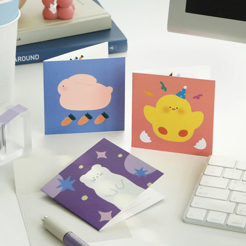 The Journal Shop - Iconic Happy Mini Card with lion design displayed beside matching envelope on white desk.