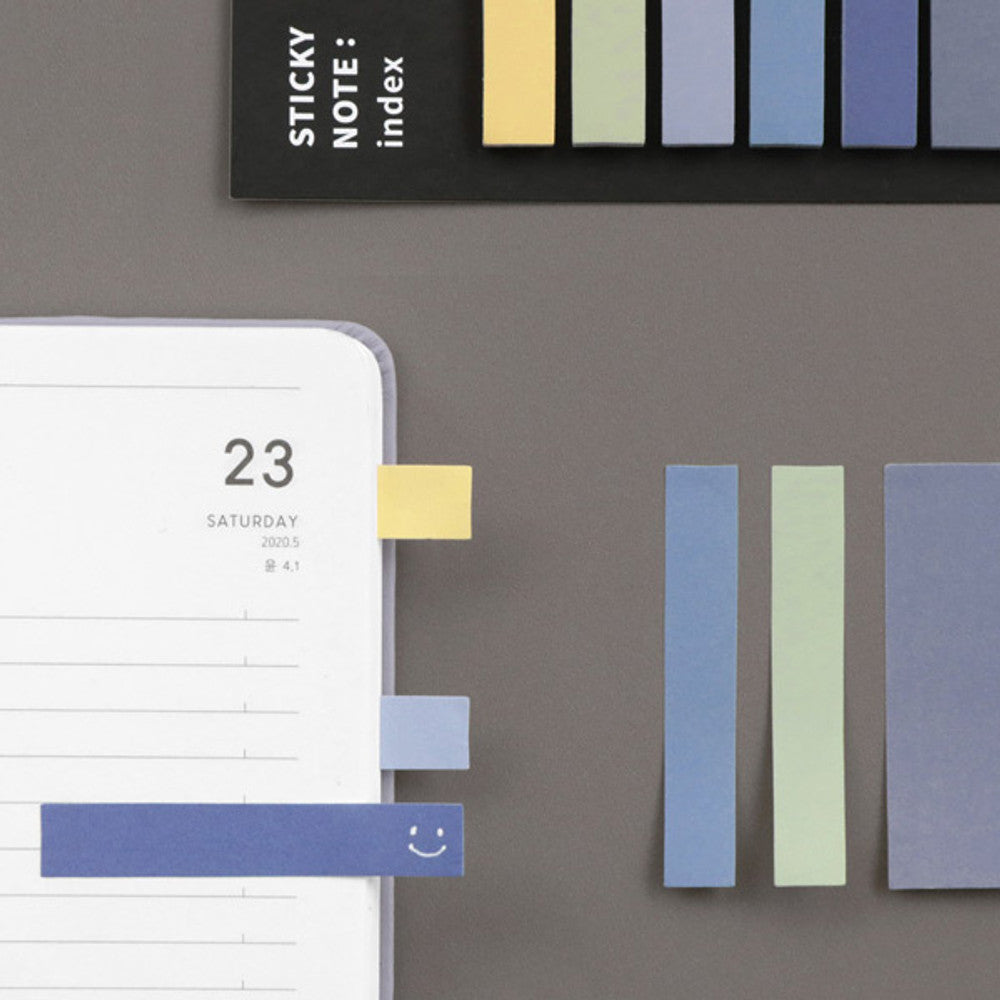 The Journal Shop - Dark and pastel sticky notes neatly aligned beside a planner page with date markings.