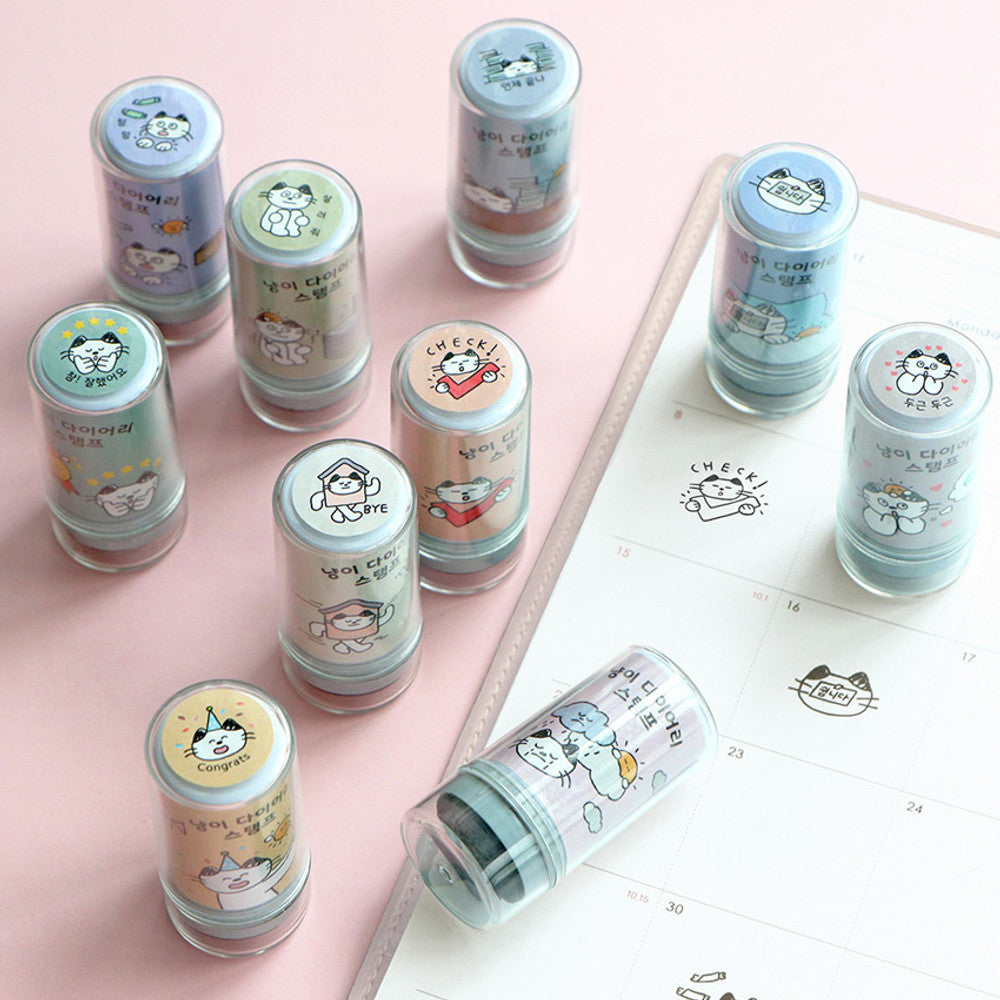 The Journal Shop - Collection of Iconic Meow Self Inking Diary Stamps in assorted pastel colours with cute cat illustrations on a pink background.