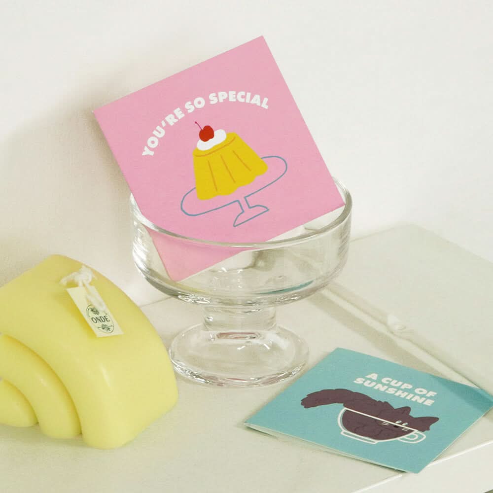 The Journal Shop - Iconic Mini Friends Card Set pink card with ice cream design displayed over the glass.