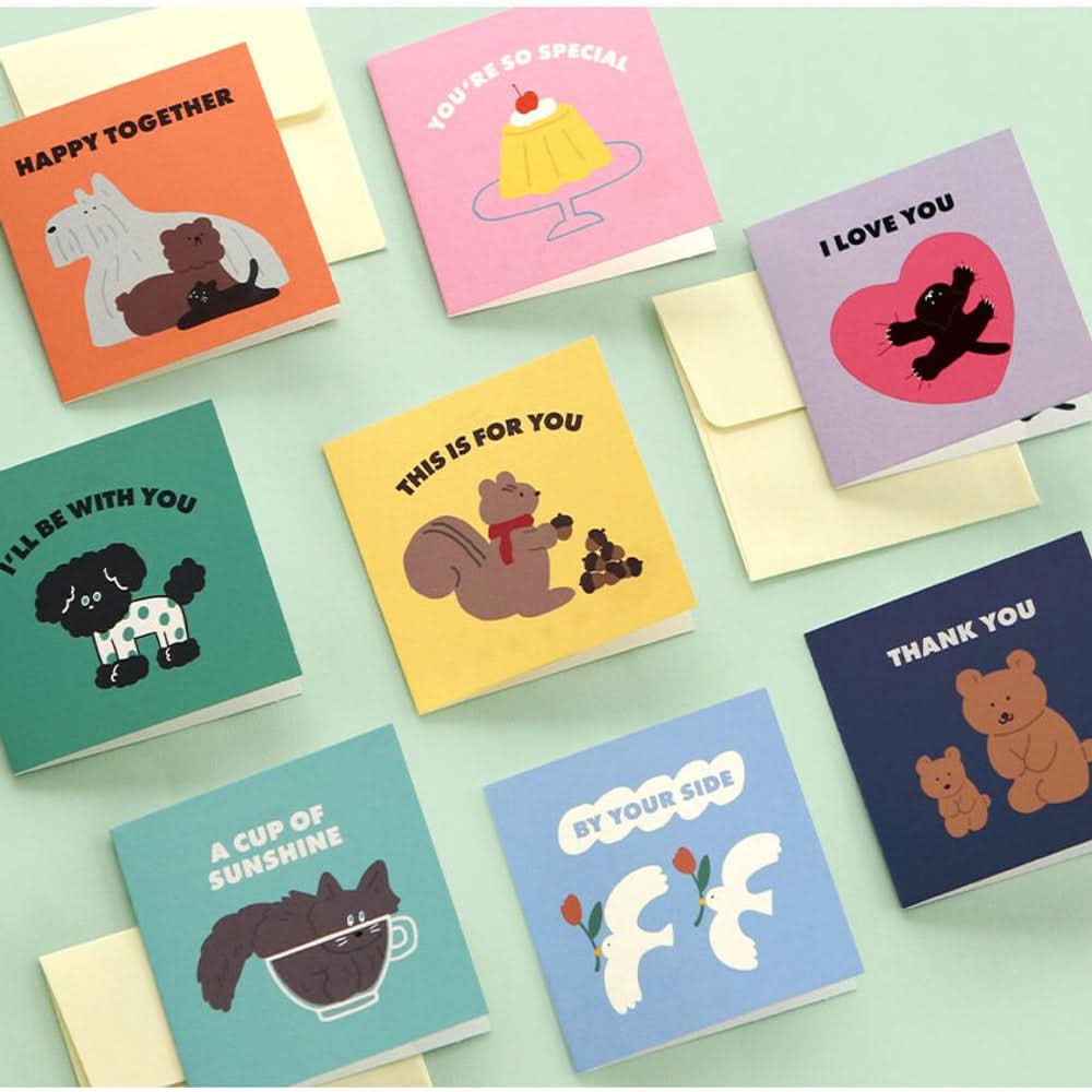 A colourful selection of Iconic Mini Friends Cards arranged neatly on a mint green surface.