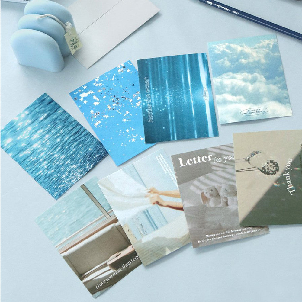 The Journal Shop - Iconic Moodscape Message Cards in assorted blue sky and ocean designs displayed with envelopes and stationery on desk.
