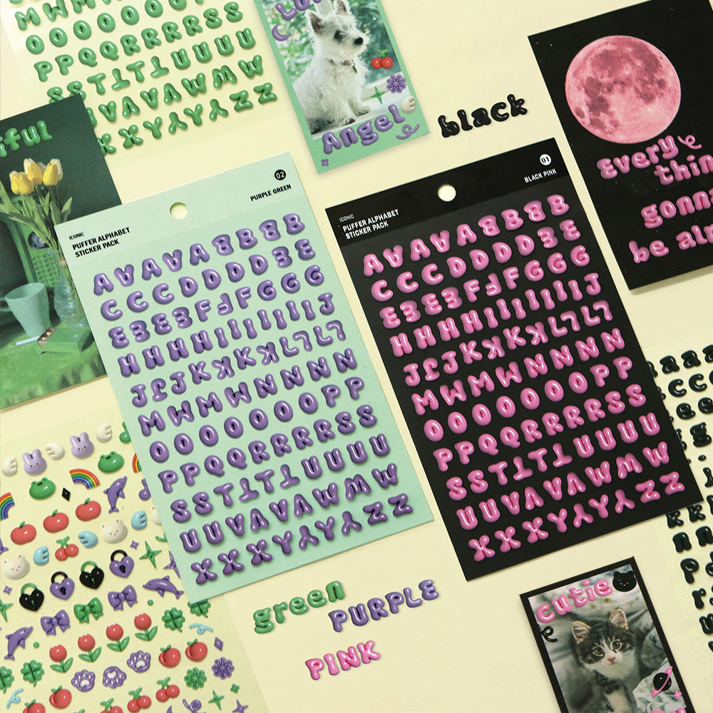 The Journal Shop - A selection of Iconic Puffer Alphabet Sticker sheets in pastel green, purple, and black displayed on a yellow surface with small decorative stickers.