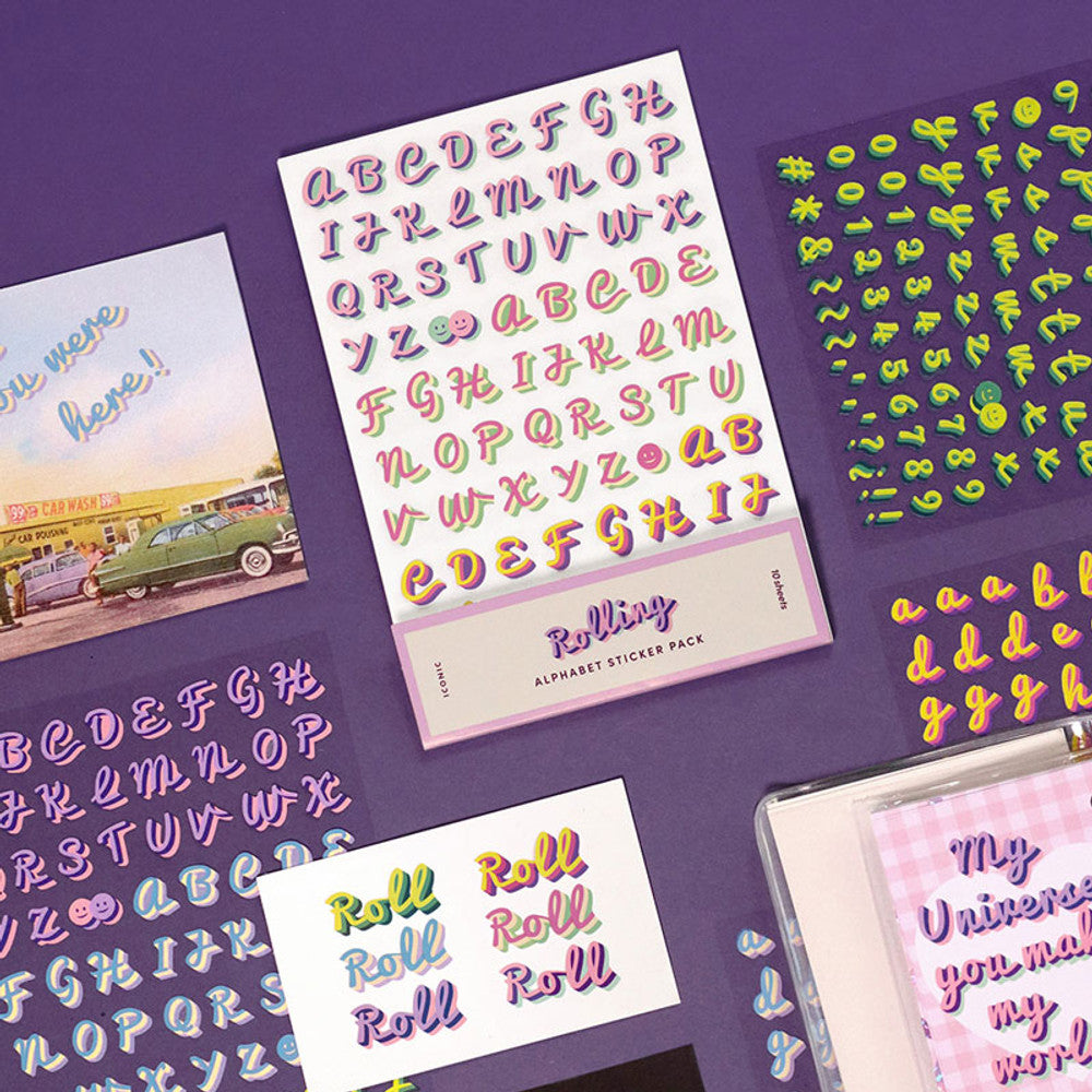 The Journal Shop - Collection of Iconic Rolling Alphabet Sticker sheets in assorted colours displayed on a purple background.