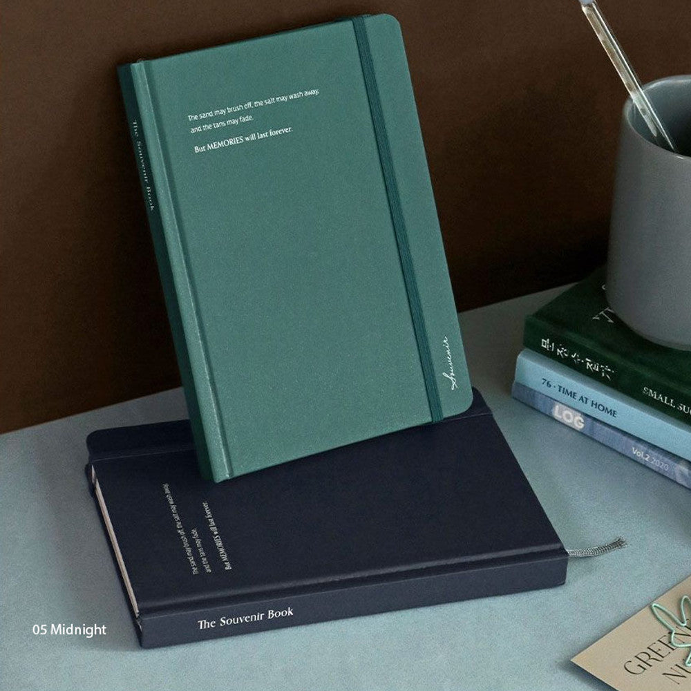 The Journal Shop - Iconic Souvenir B6 Band Notebook lined hardcover journal in midnight blue and green covers stacked on desk.