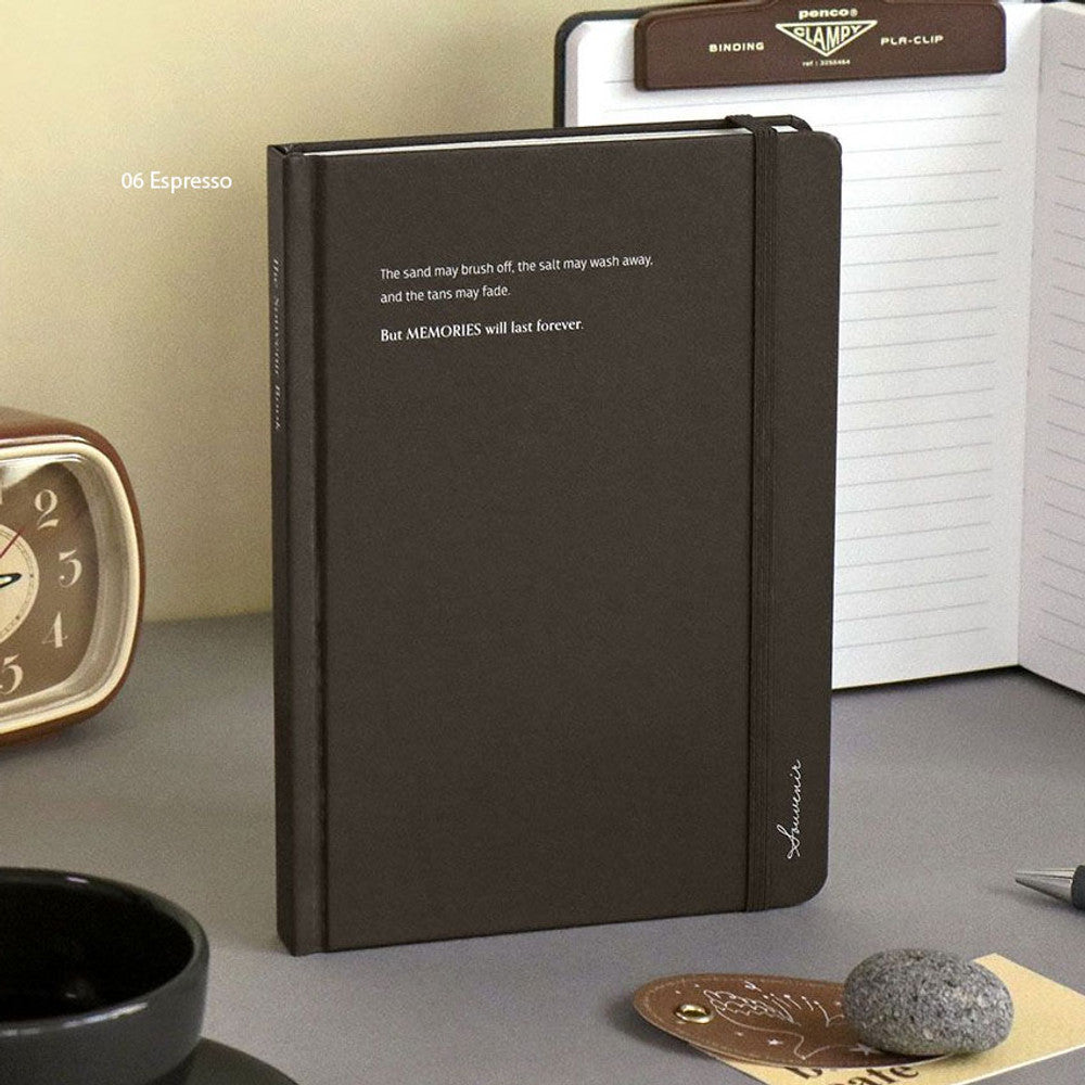 The Journal Shop - Iconic Souvenir B6 Band Notebook dark brown hardcover journal displayed upright on desk with pen.