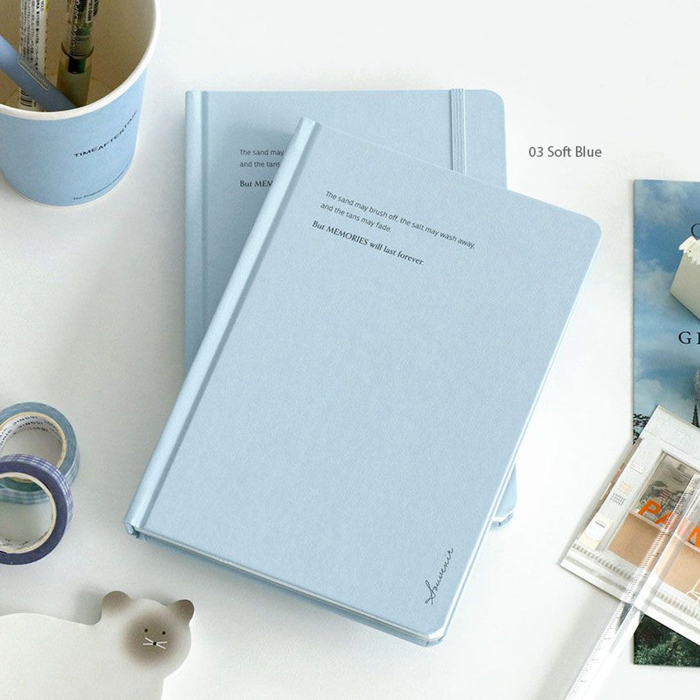 The Journal Shop - Iconic Souvenir B6 Band Notebook light blue hardcover journal displayed on table with other stationery.