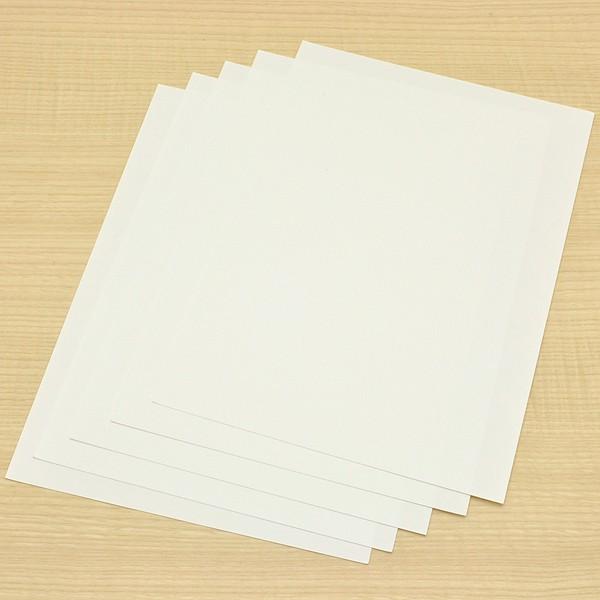 Flat lay of several individual SUITO blotting paper sheets on a wooden surface.
