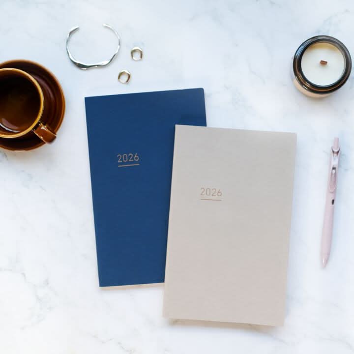 Collection of Kokuyo Jibun Techo Lite 2026 Mini B6 Slim Diaries in two colours styled with notebooks and coffee.