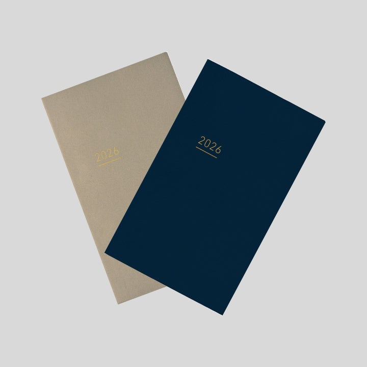 overs of Kokuyo Jibun Techo Lite 2026 Mini B6 Slim Diary in navy and beige with gold-foil year detail.