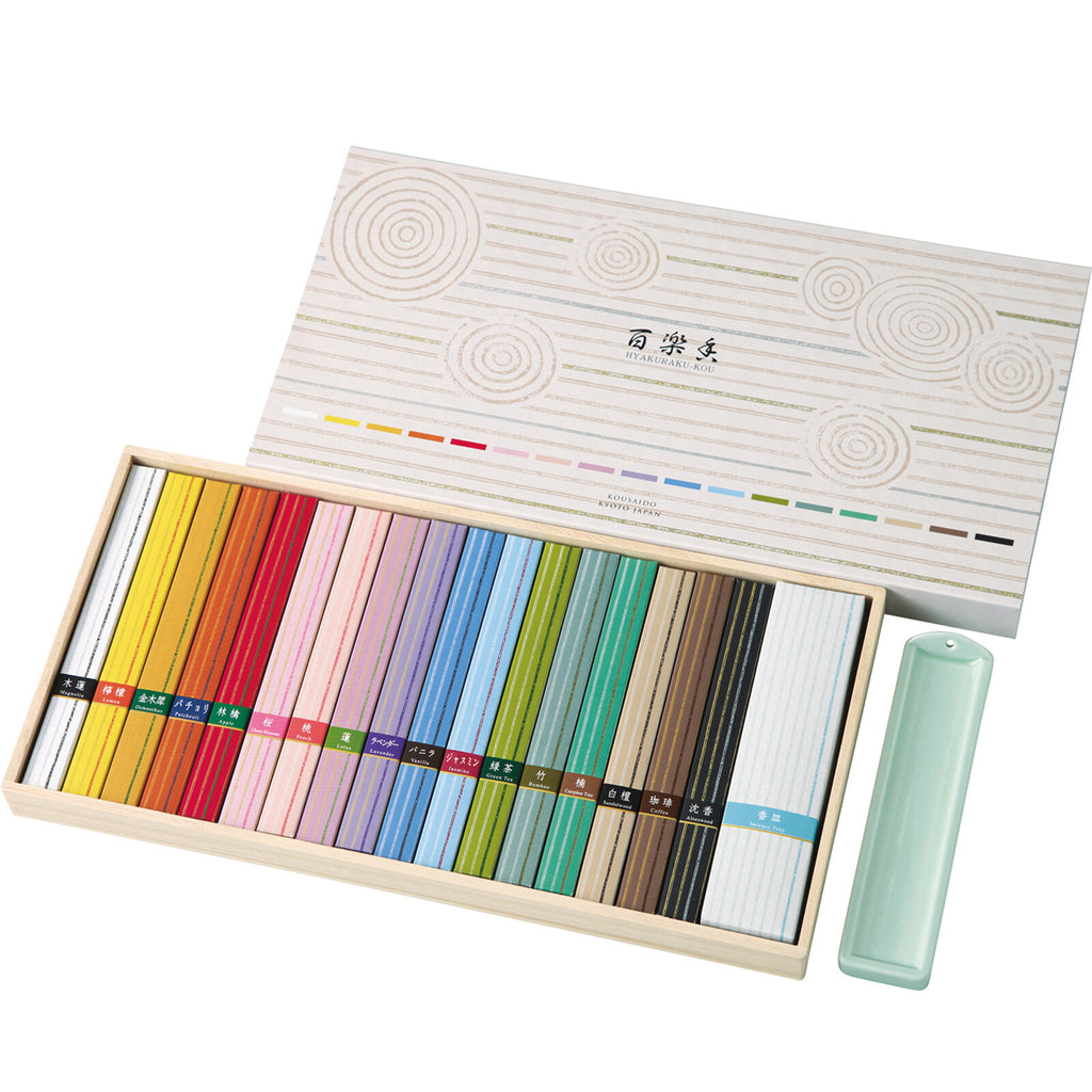 Open Kousaido Hyakurakukou Incense Assortment box displaying seventeen colourful types of Japanese incense sticks arranged neatly with a ceramic incense holder.