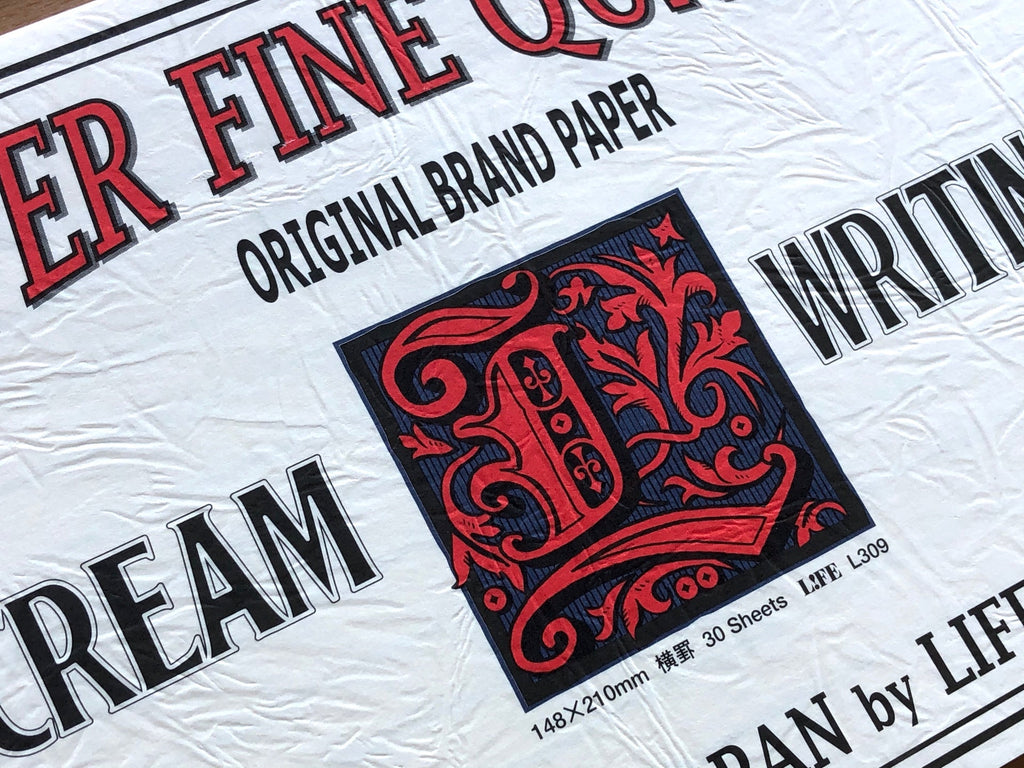 The Journal Shop - Life L-Brand Cream Ruled Writing Pad A5 detailed view of cover text and logo print with fine lettering.